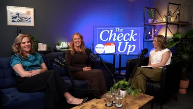 Three women sit in front of mics