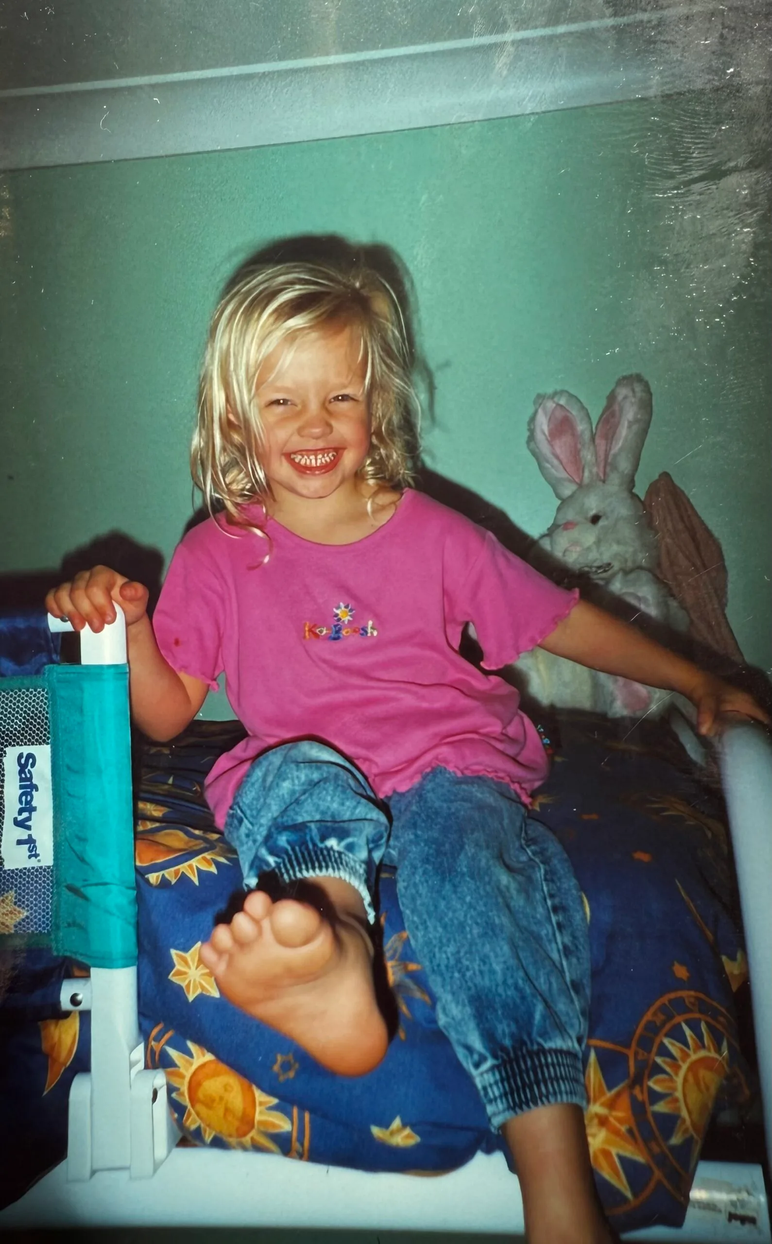 young girl pink top on bed