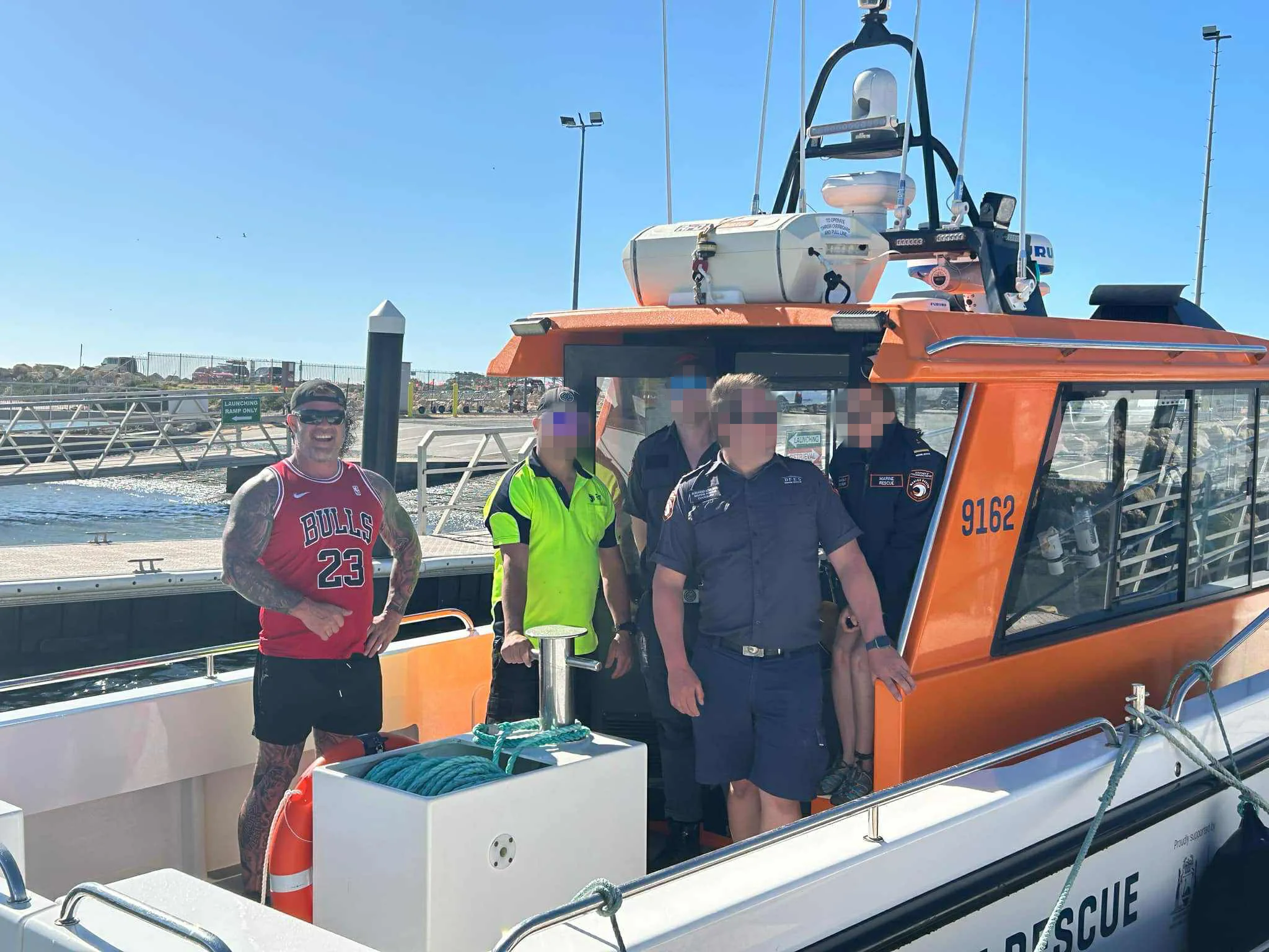 Image of man on fishing boat standing with rescuers