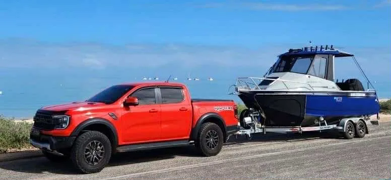 Image of red ute towing blue boat