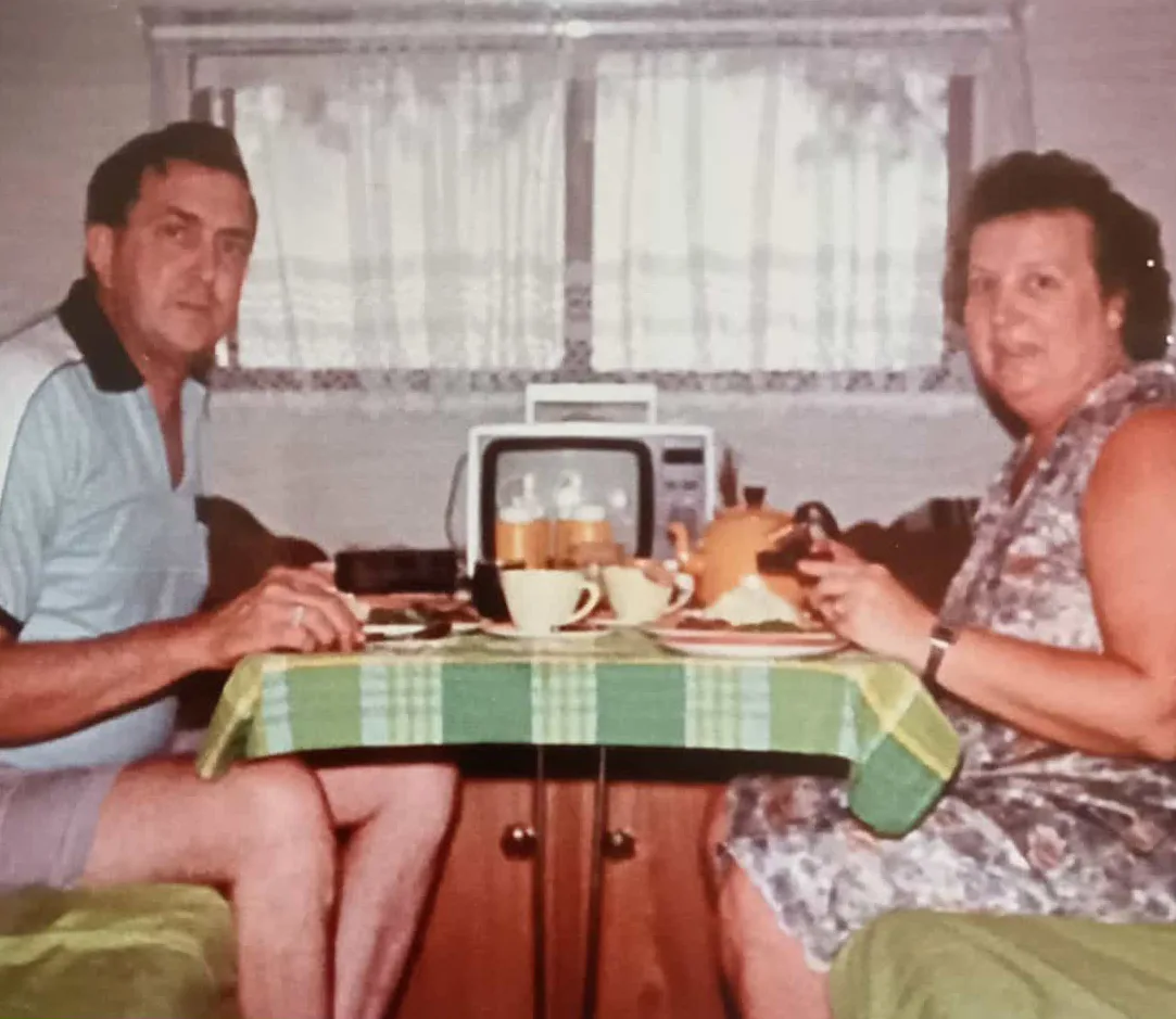 Image of man and woman drinking tea in a caravan
