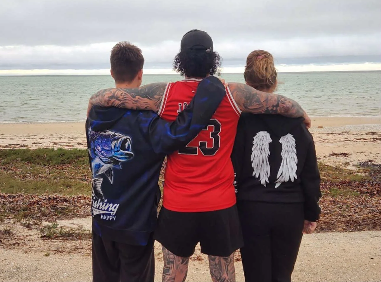 Image of three people looking out at the beach