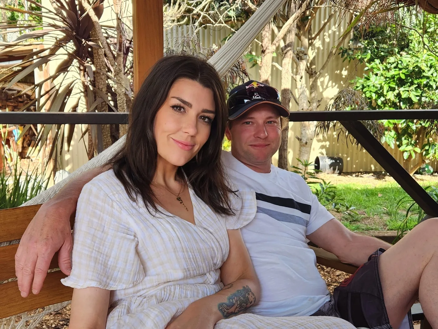 women in plaid dress and man in striped shirt and cap