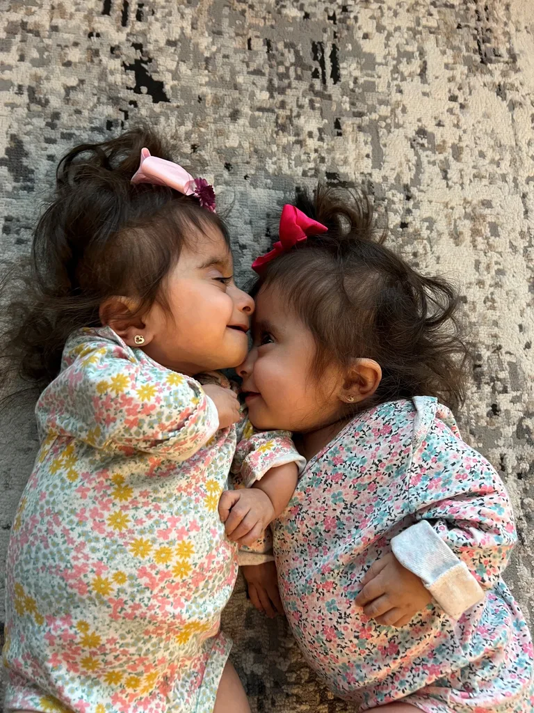 Twins girls lying down facing each other