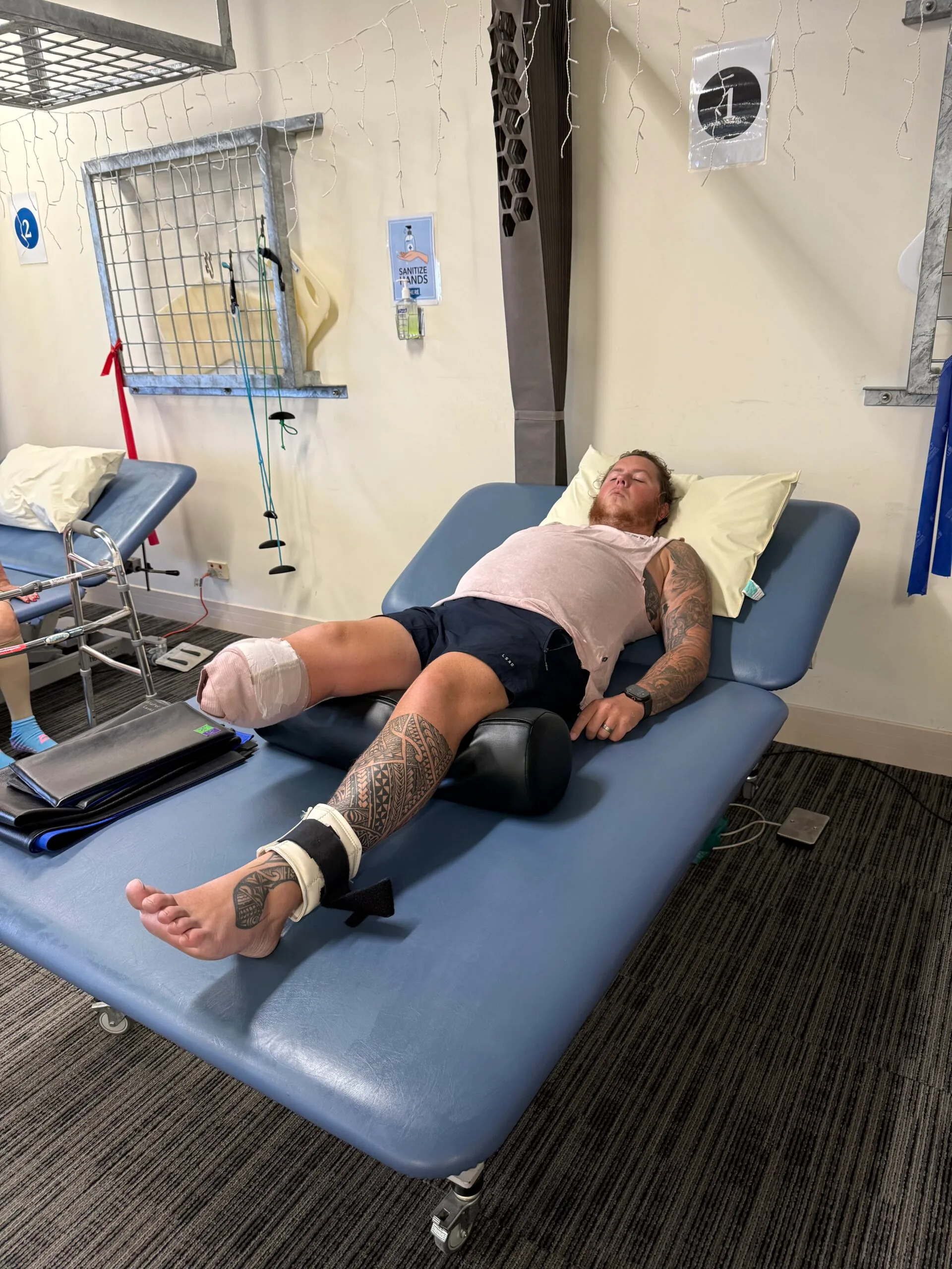 man lying on hospital bed with one leg