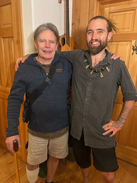 two men one younger and one older arm in arm