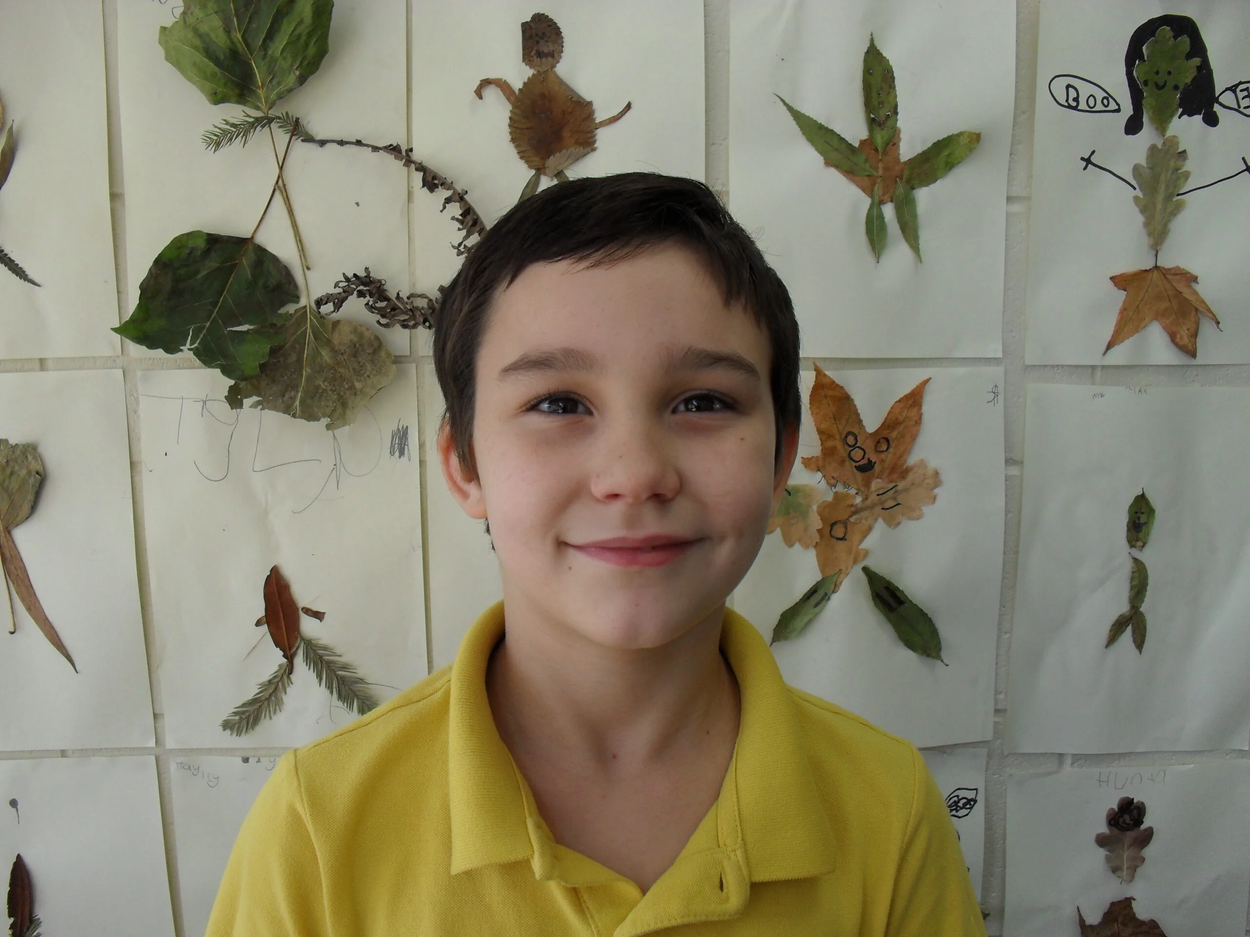 a brunette child wearing a yellow shirt