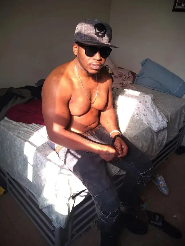 man sitting on bed with no shirt on