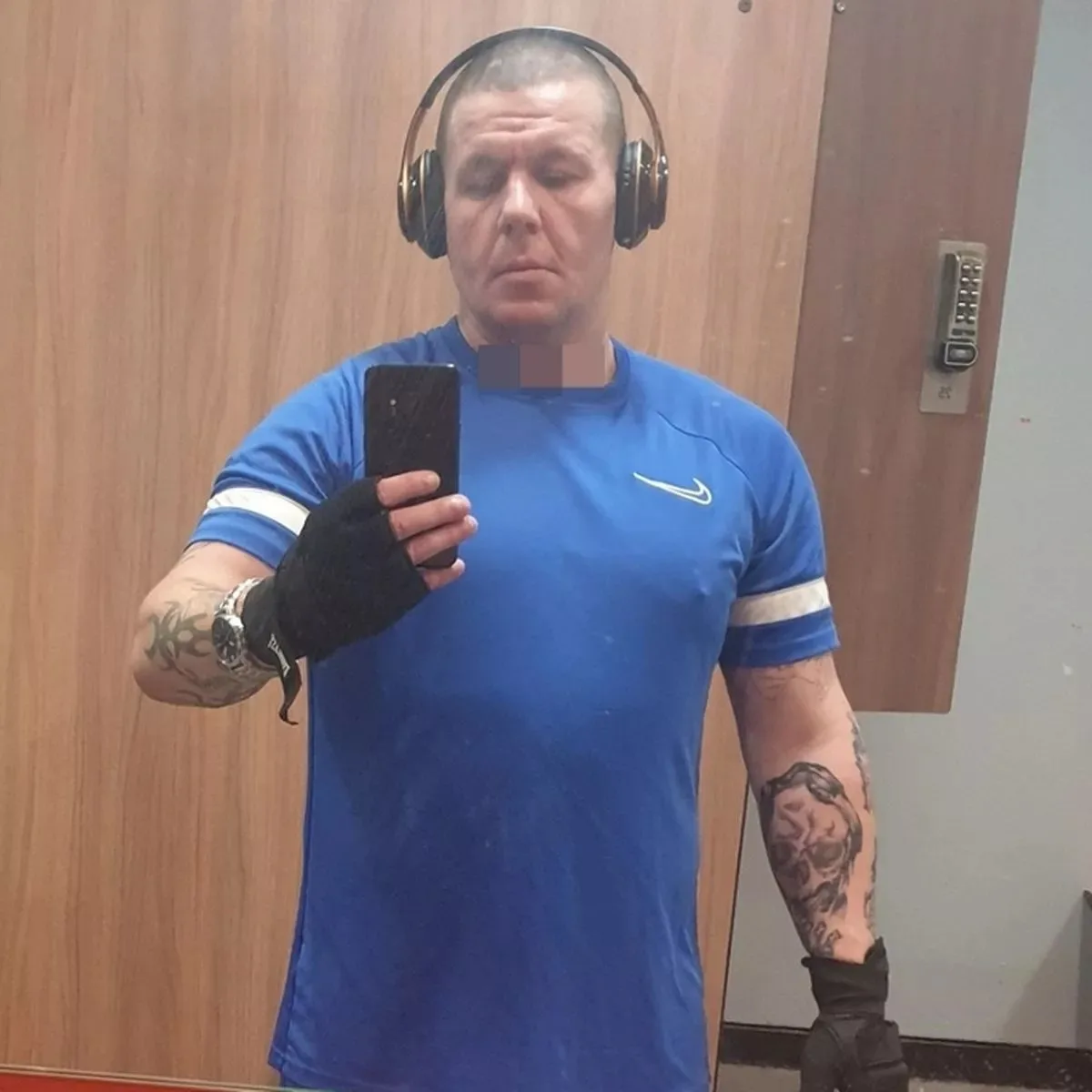 A man wearing headphones looking at a phone