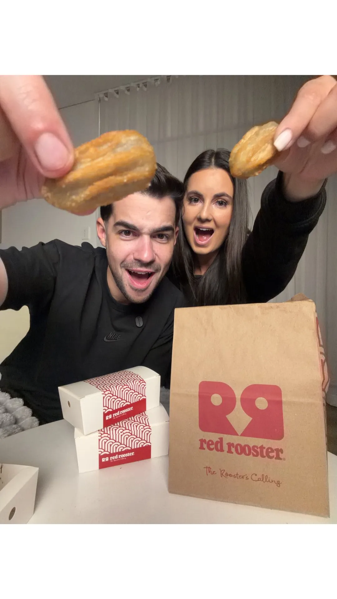 A couple holds up Red Rooster's Choc Churro Bites.