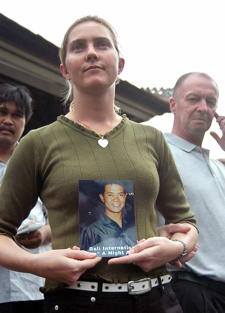 Image of woman holding photo of husband lost in the bali bombings