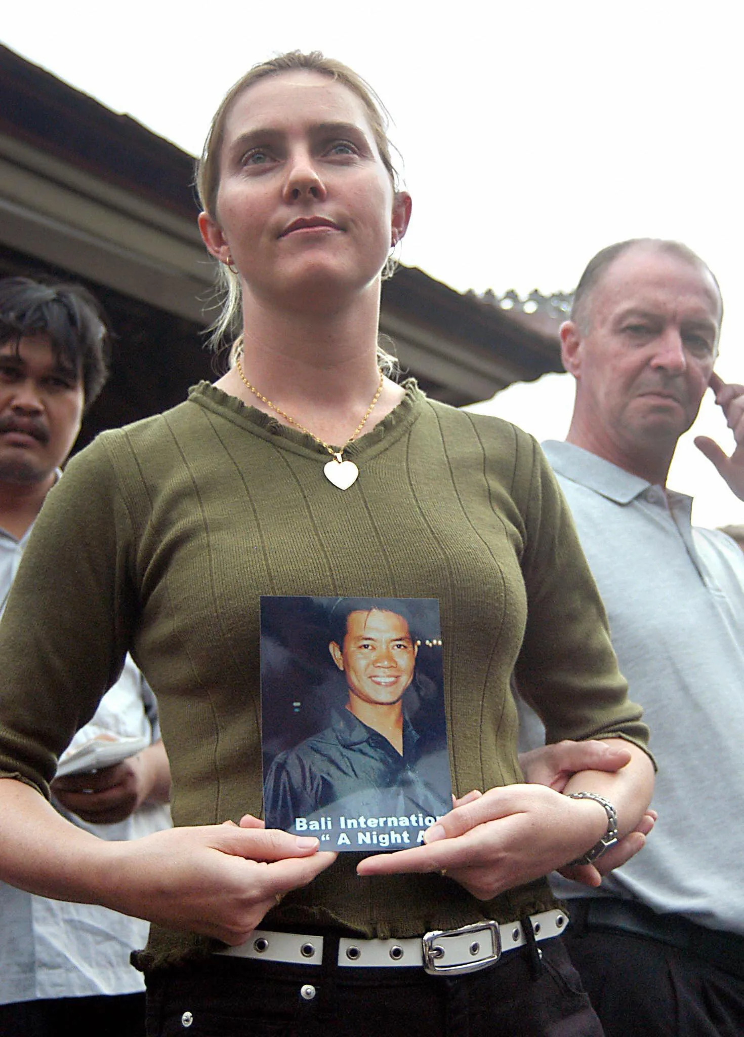Image of woman holding photo of husband lost in the bali bombings