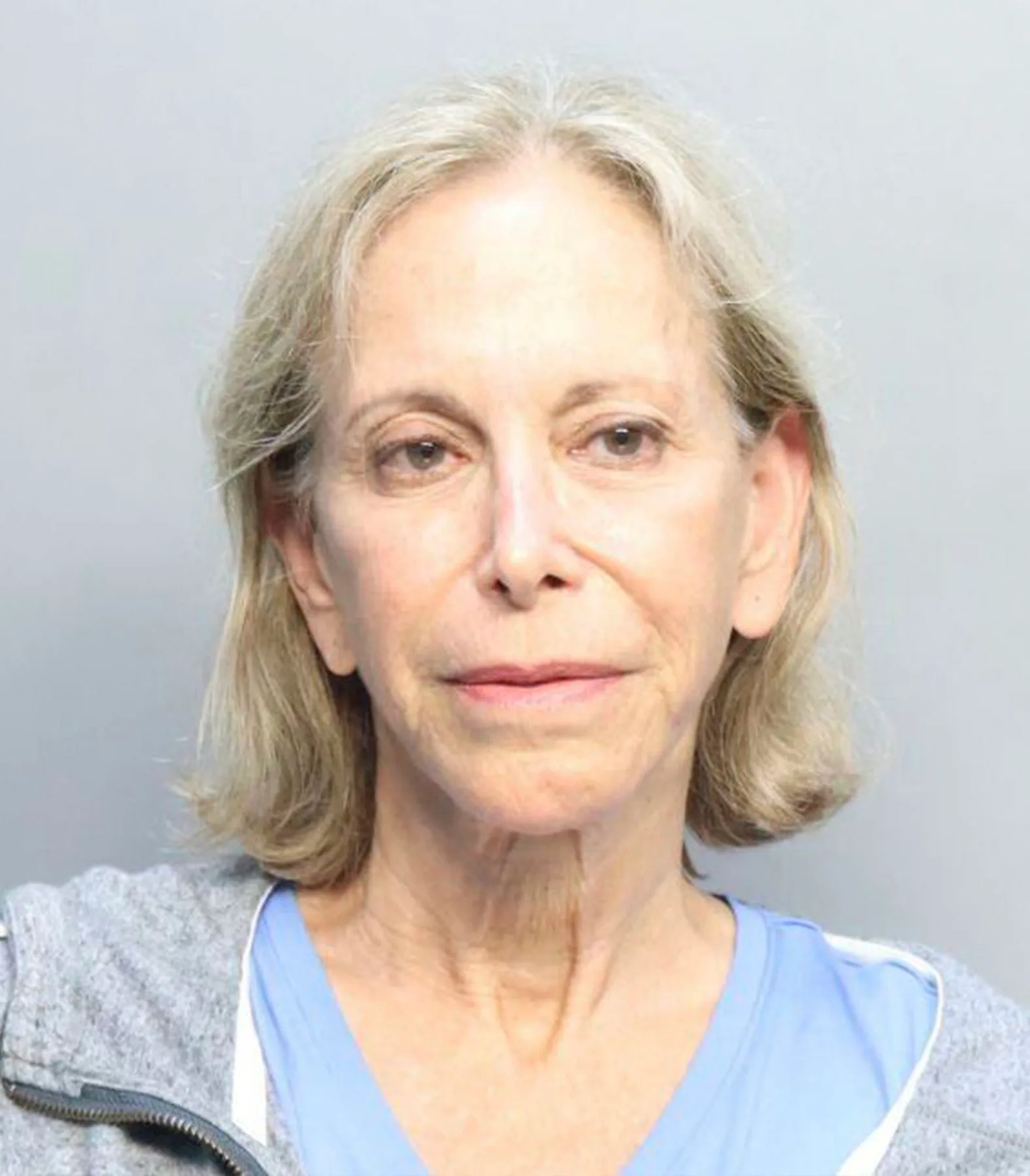 older woman with short hair and grey hoodie on