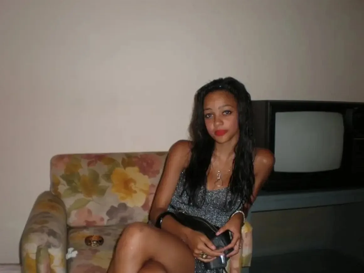 Imaarl during an episode. She is sitting on a couch.