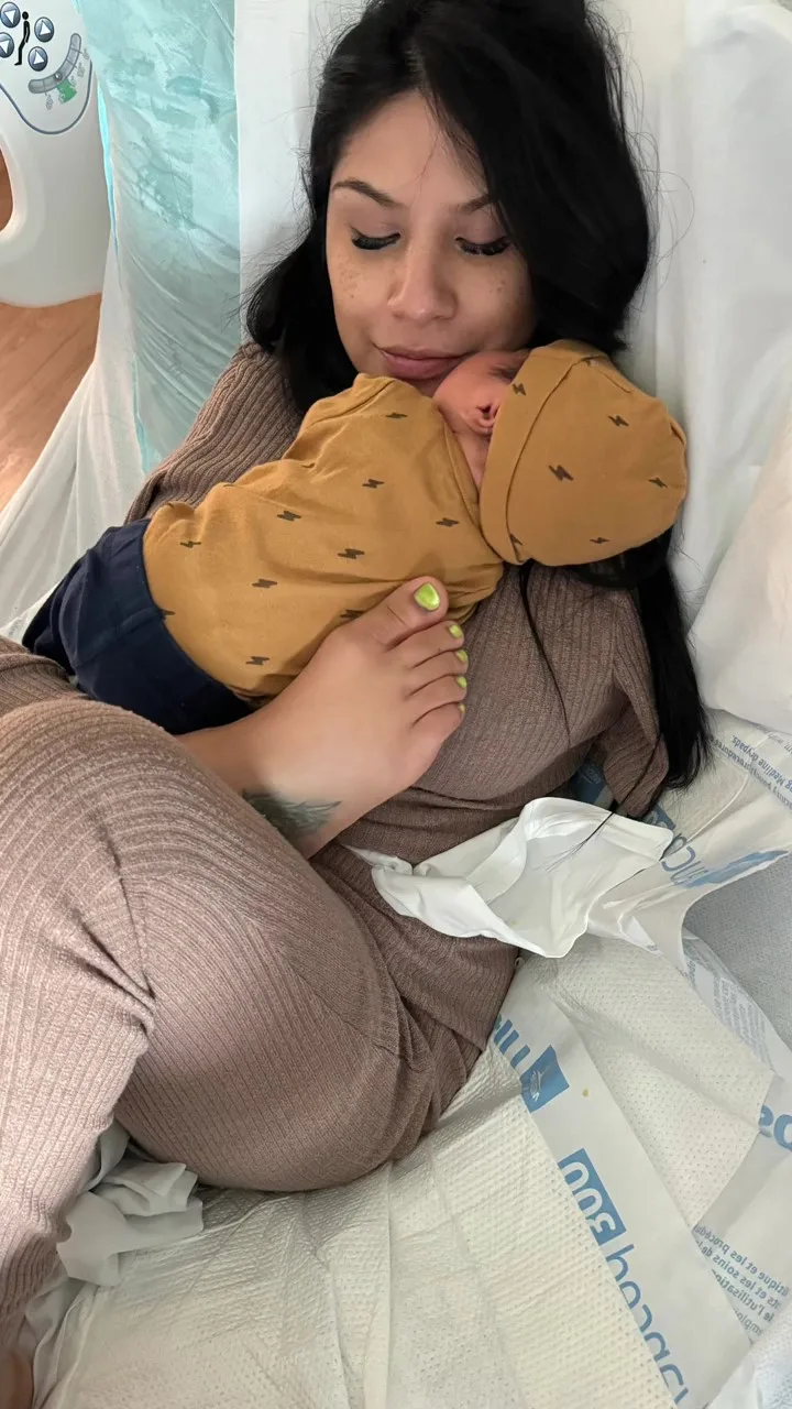 Image of woman holding baby with feet