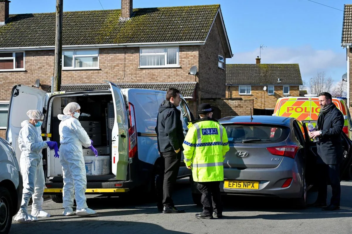 police cars and officers in front of brick house 