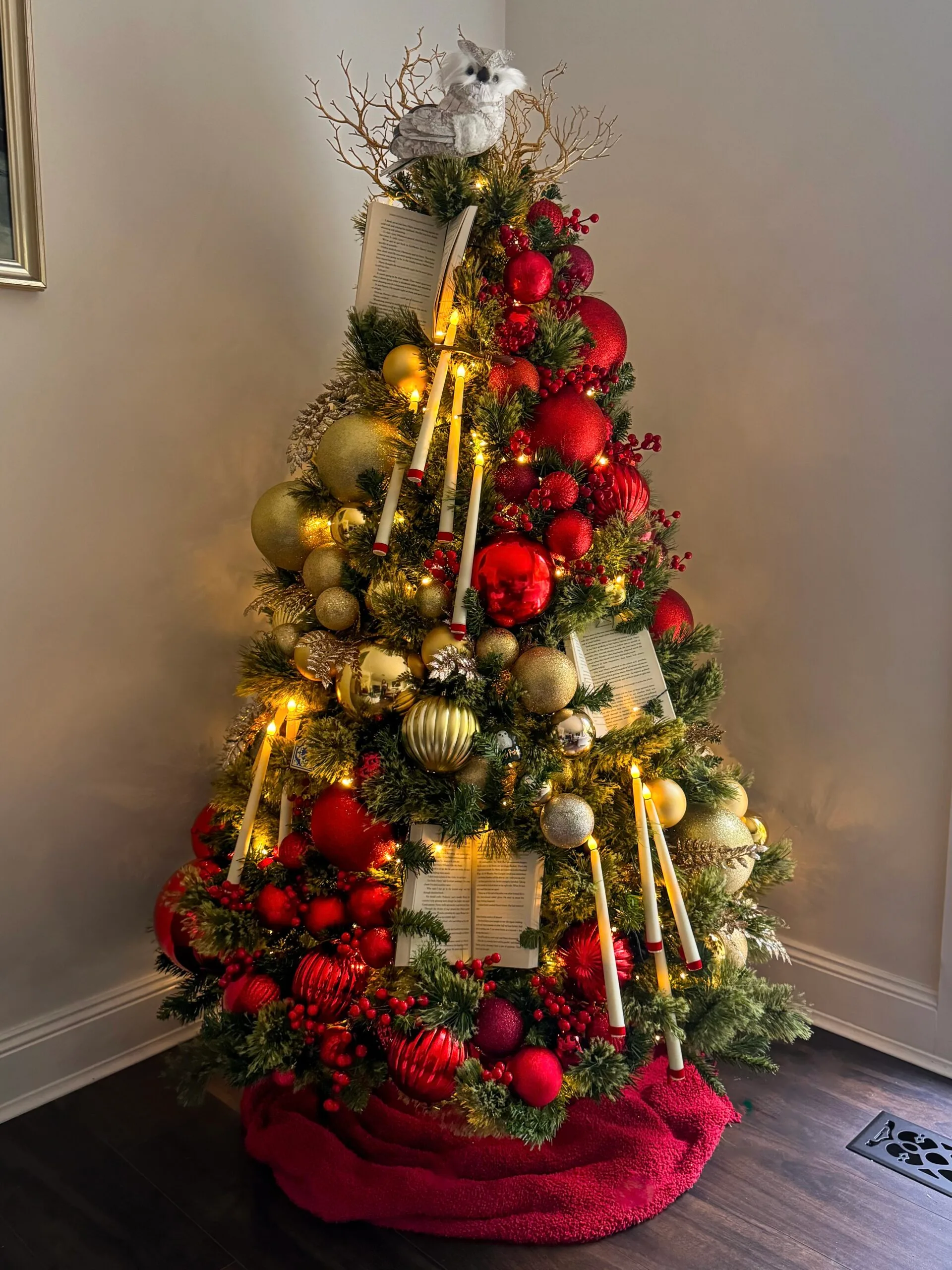red and gold ornaments on a  fake tree with candles 
