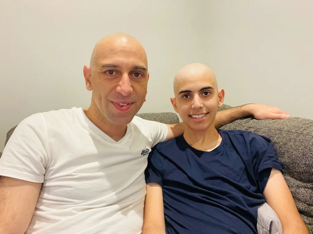 A man and a teeage boy with their heads shaved