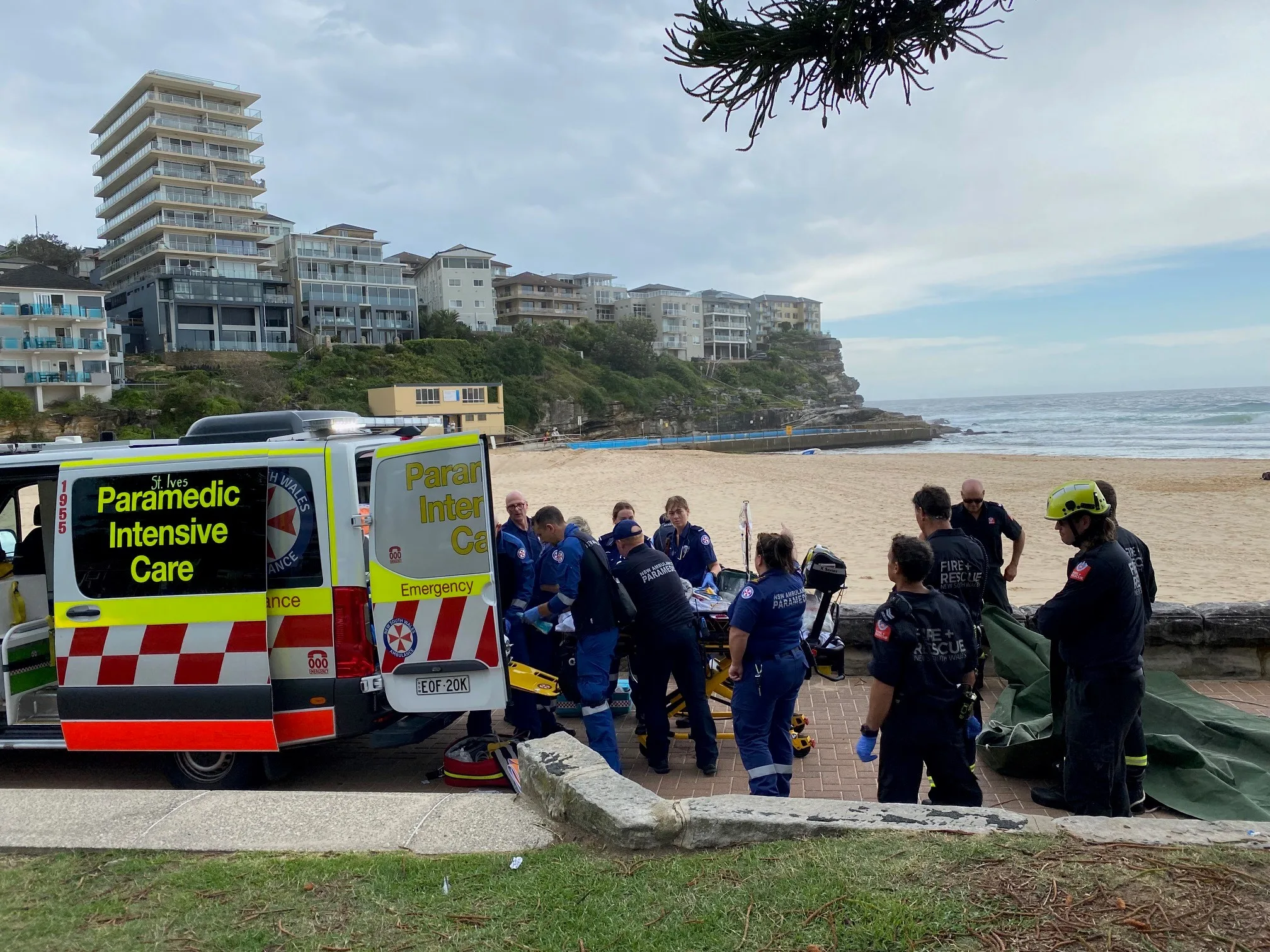 large group of paramedics and rescue people helping a boy on a stretcher 