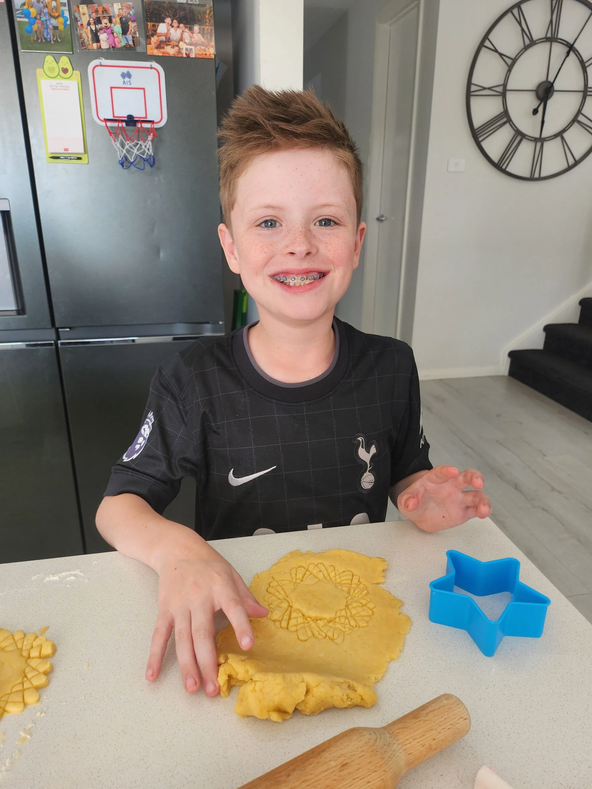 young boy icing cookies