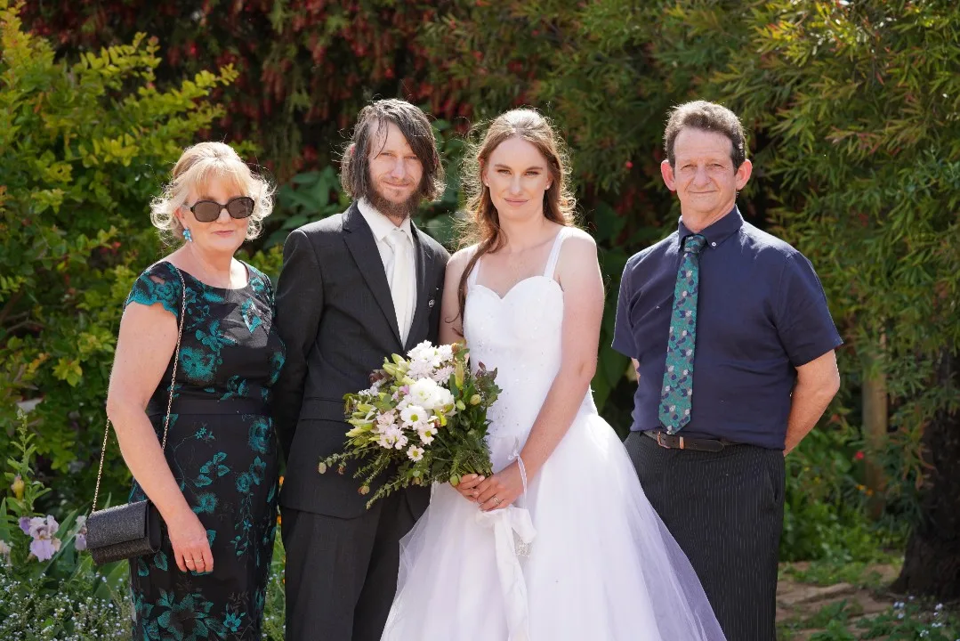 woman at a wedding with bride and groom 