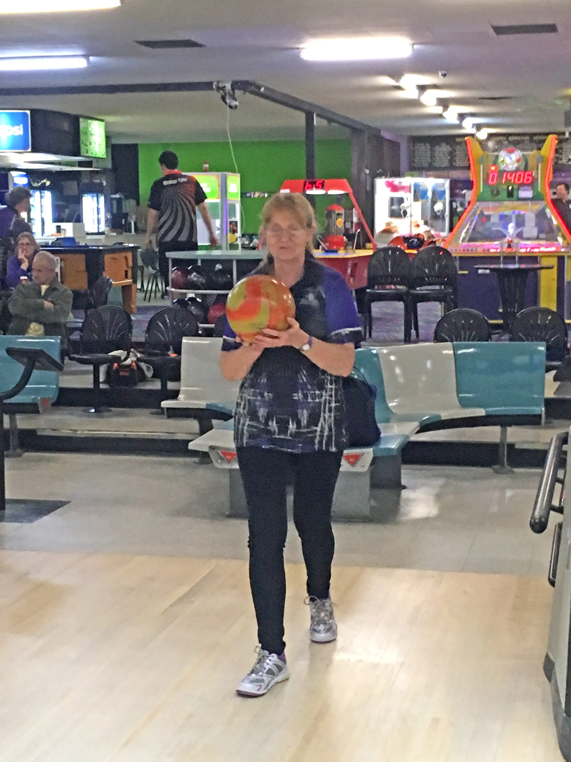 woman wearing purple shirt in bowling alley