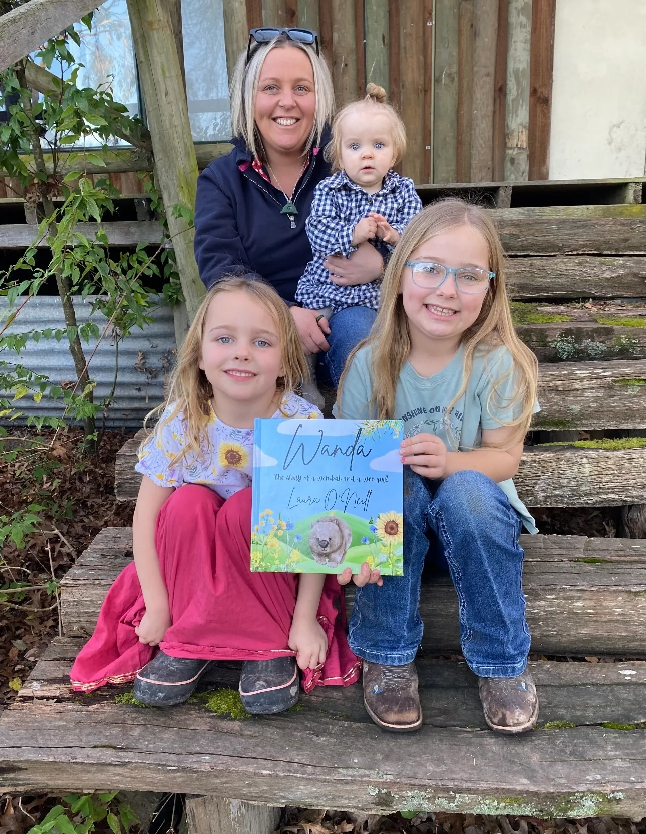 a family sit on stairs holding a book 