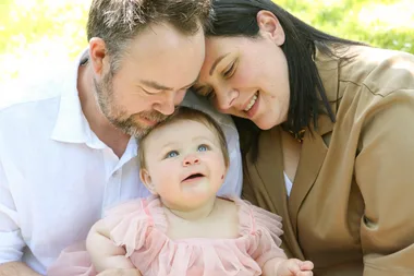 Image of husband and wife with their newborn girl