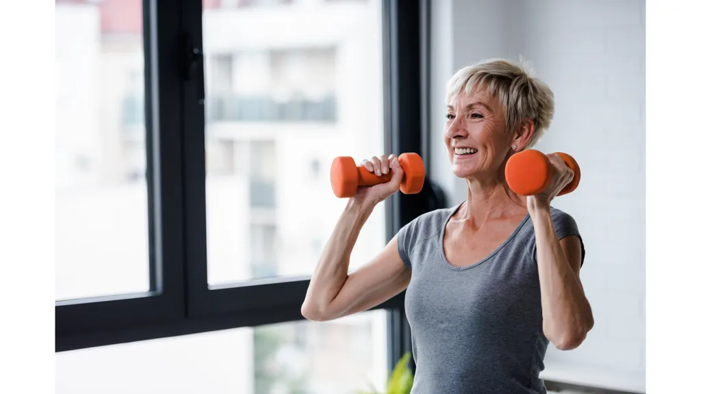 A woman smiles while lifting weights.