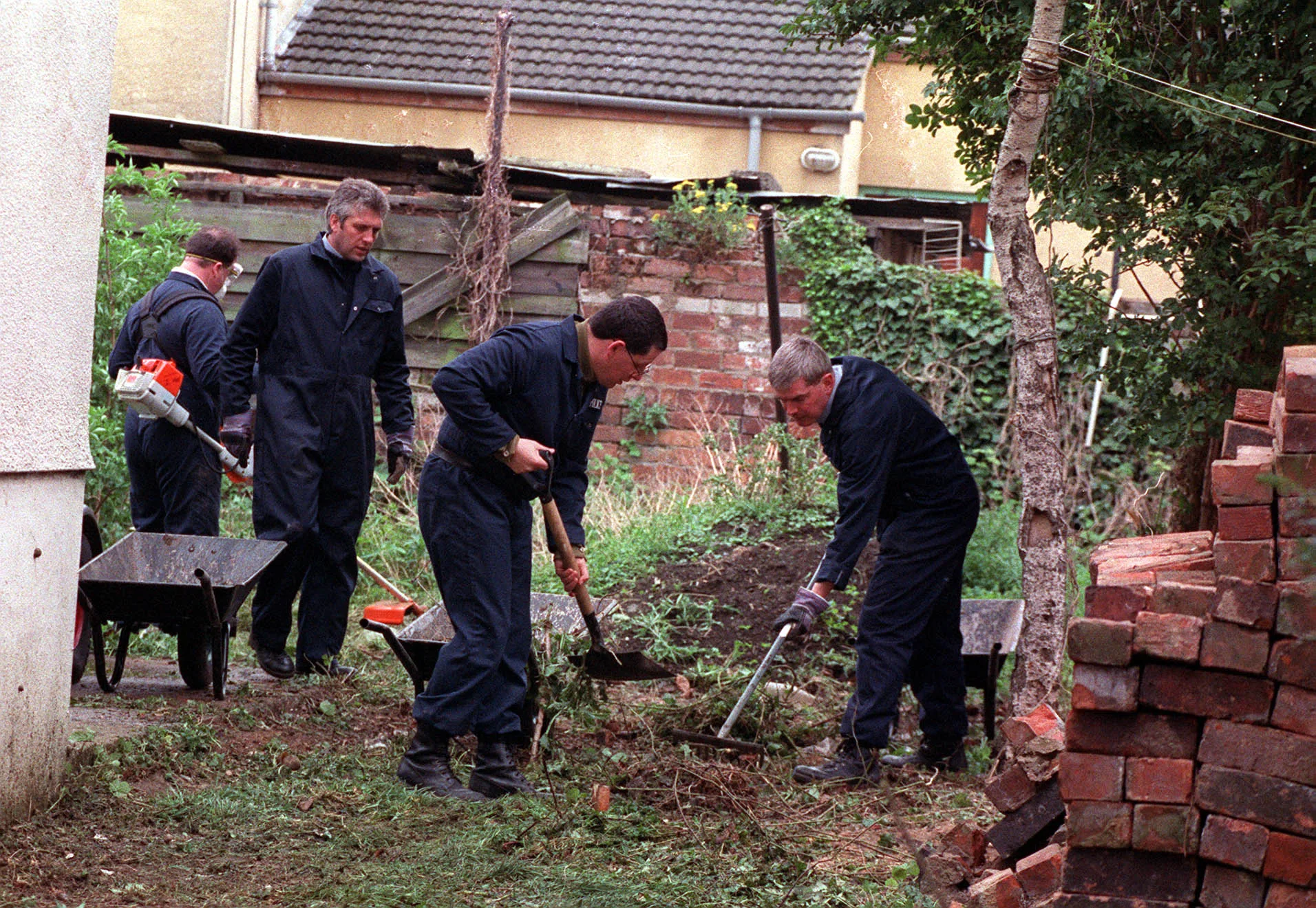 police digging with shovels in yard