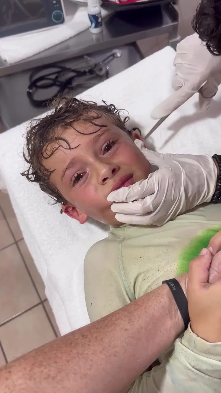boy with tears in eyes as crab is removed 