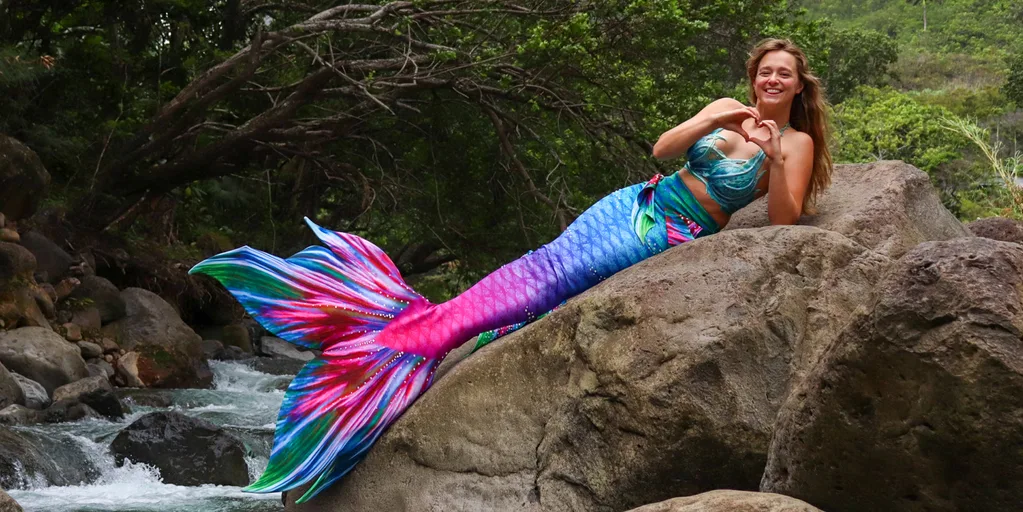 Image of woman laying on a rock wearing a mermaid tail