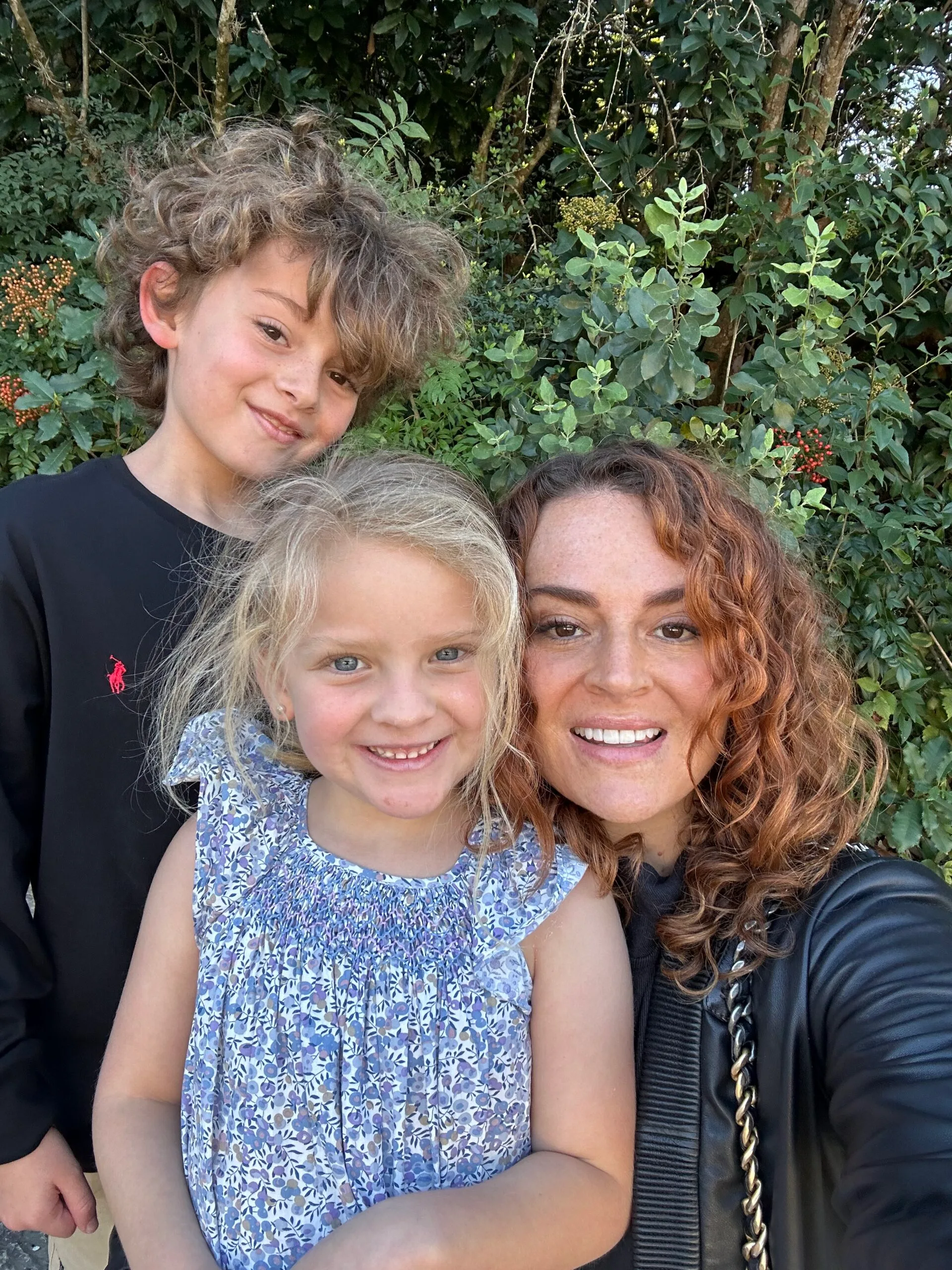 mother with daughter in blue dress and son with curly hair 