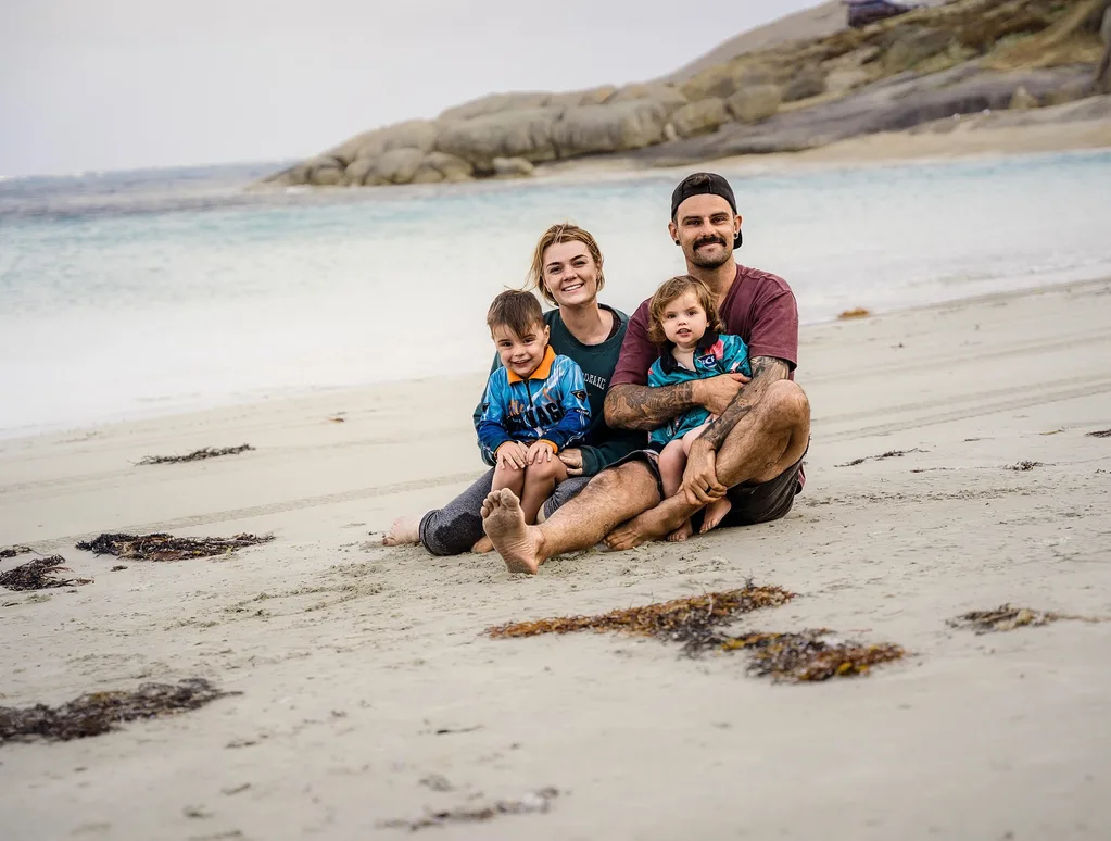 Image of family of four sitting on the beach