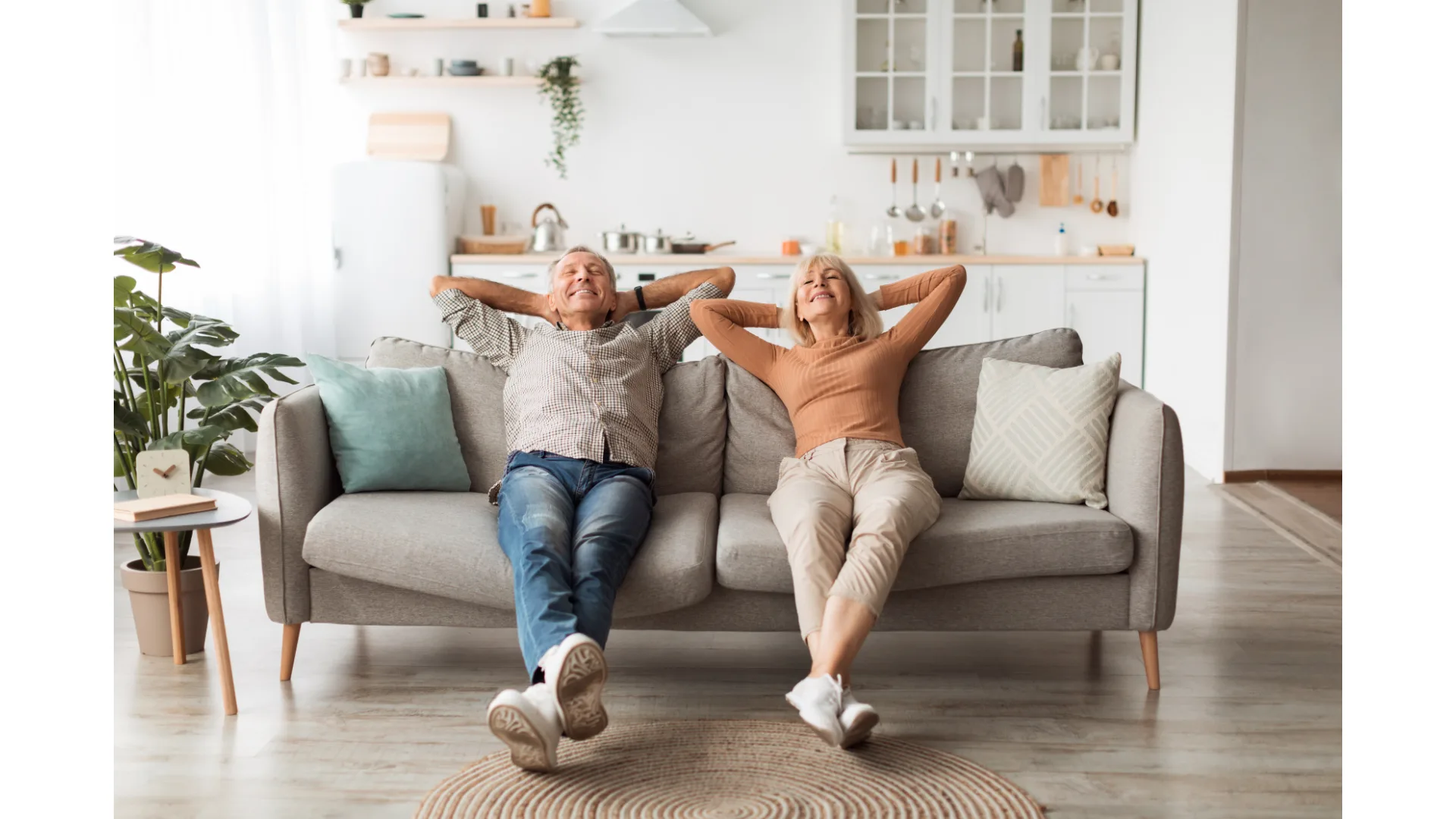 An older couple looks relaxed as they recline on a couch.