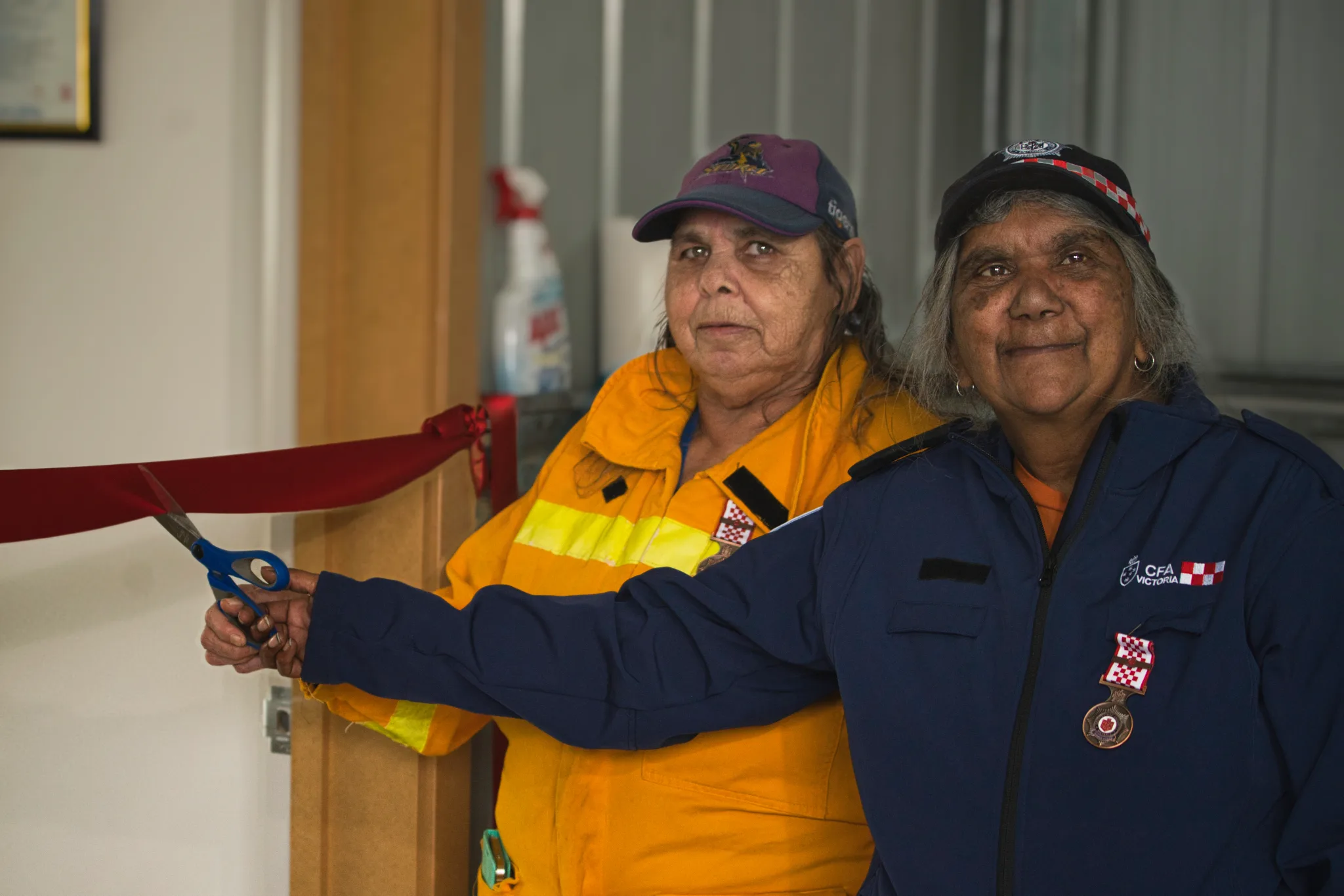 Two first nations women cutting ribbon 