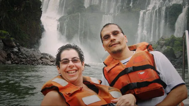 two people wearing orange life vests at waterfall 