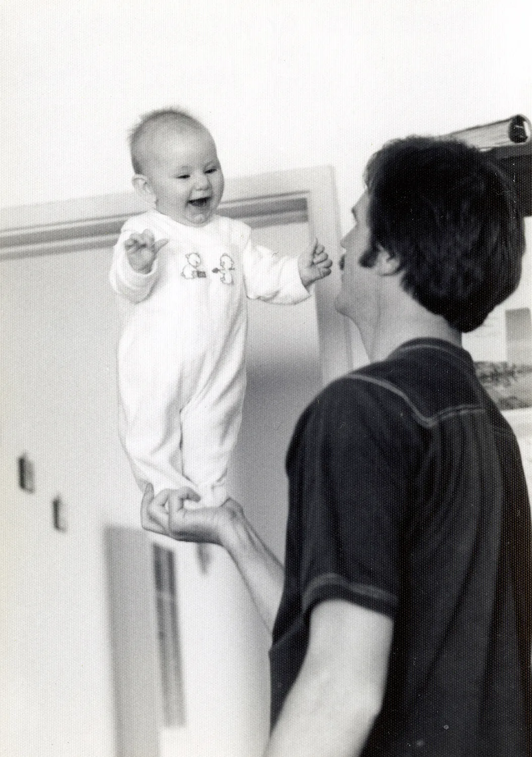 man balancing baby on hands