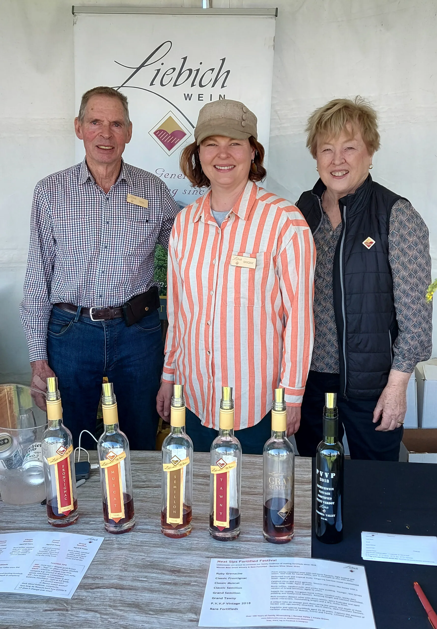 Briony and her parents Ron and Janet standing in front of a stall at a beer and wine festival