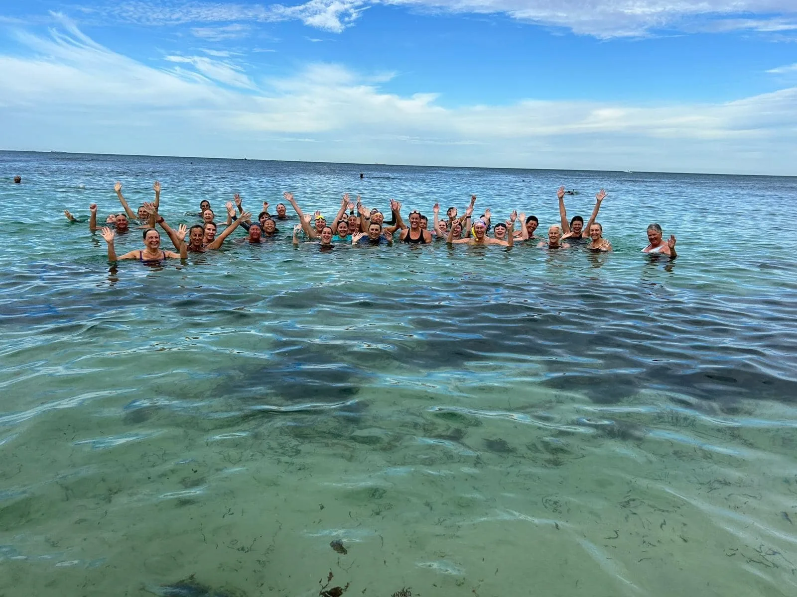 a group of women in ocean smiling for the camera