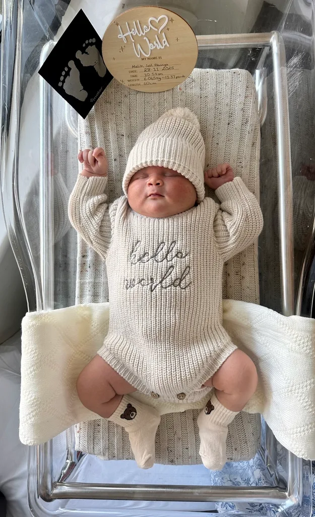 Image of newborn wearing baby onesie and beanie