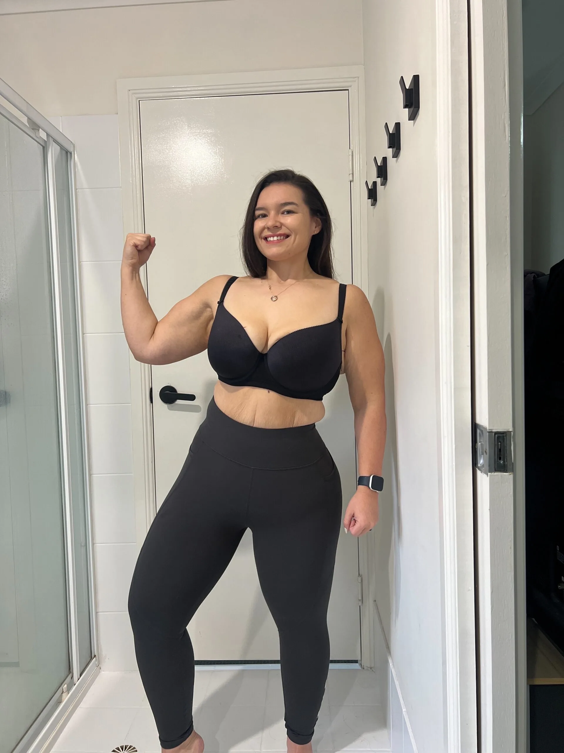 woman posing in all black showing off muscles 