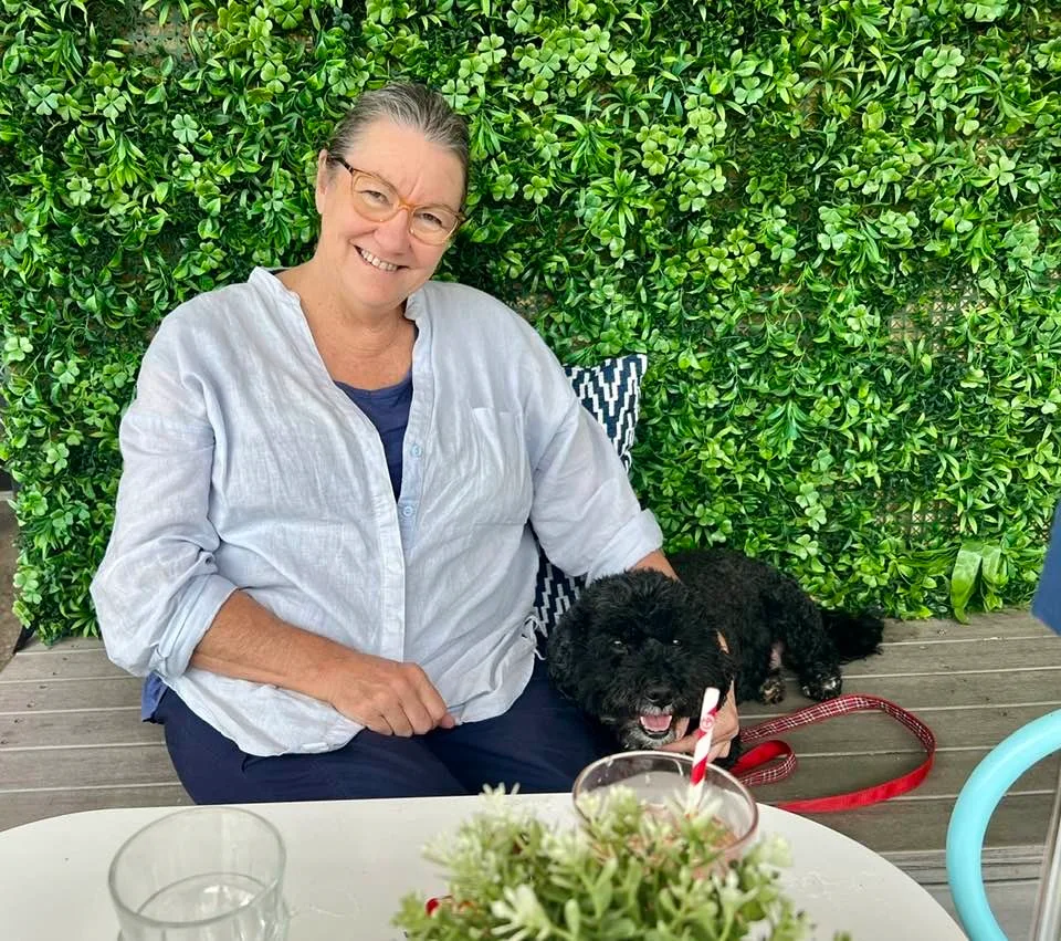 women in white linen shirt with dog