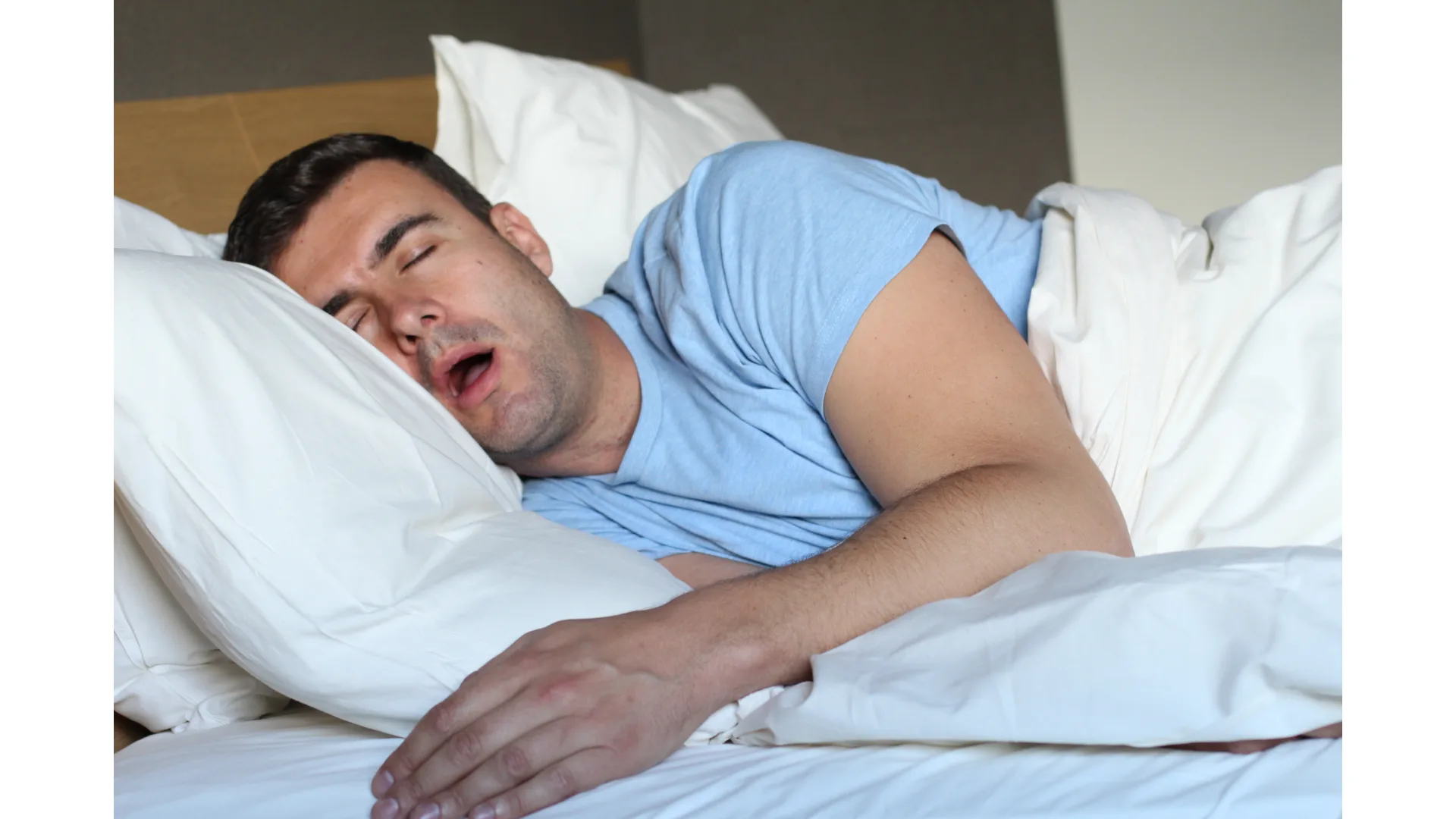 A man snores, while hugging his pillow.