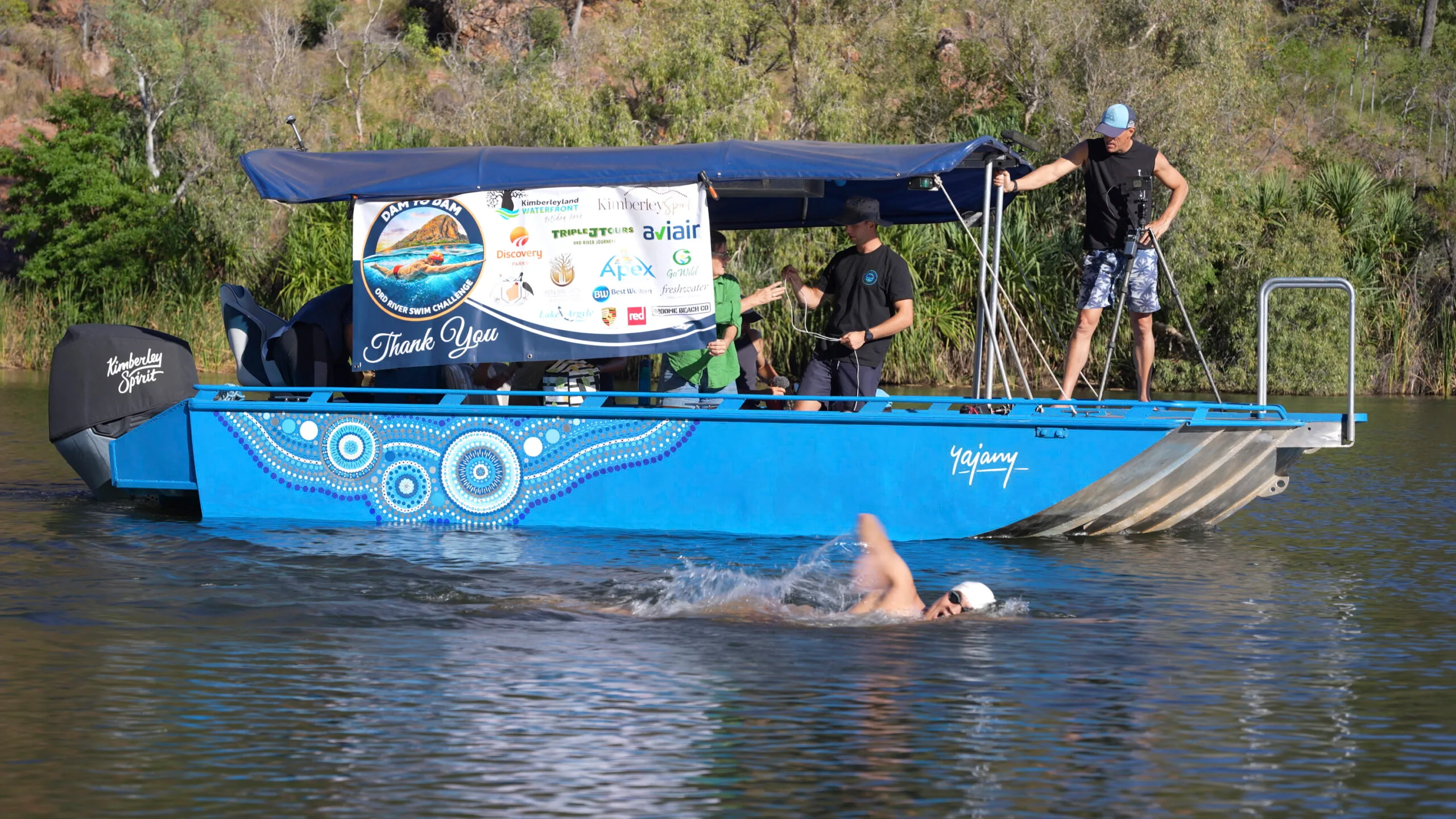 man swimming beside boat