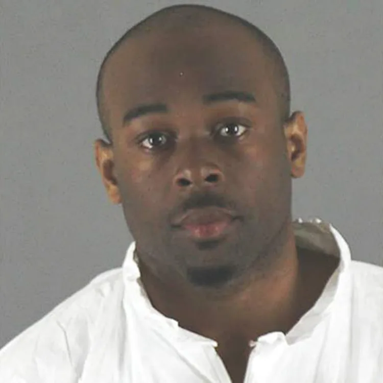 Image of perpetrator. He has brown eyes and short, dark hair. He is wearing a white shirt.