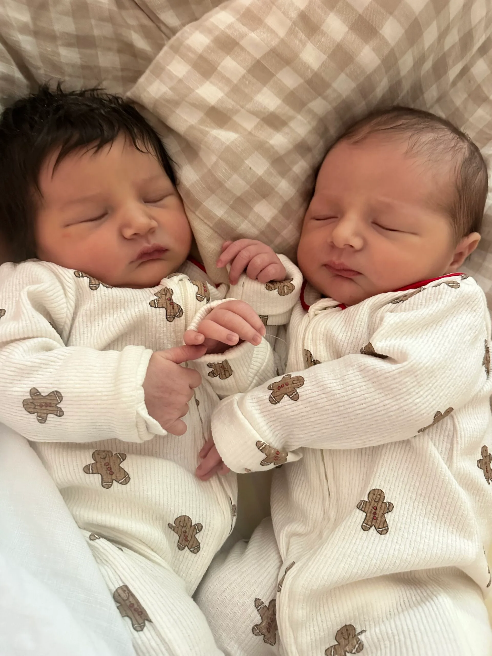 two babies wearing onsies with gingerbread on them