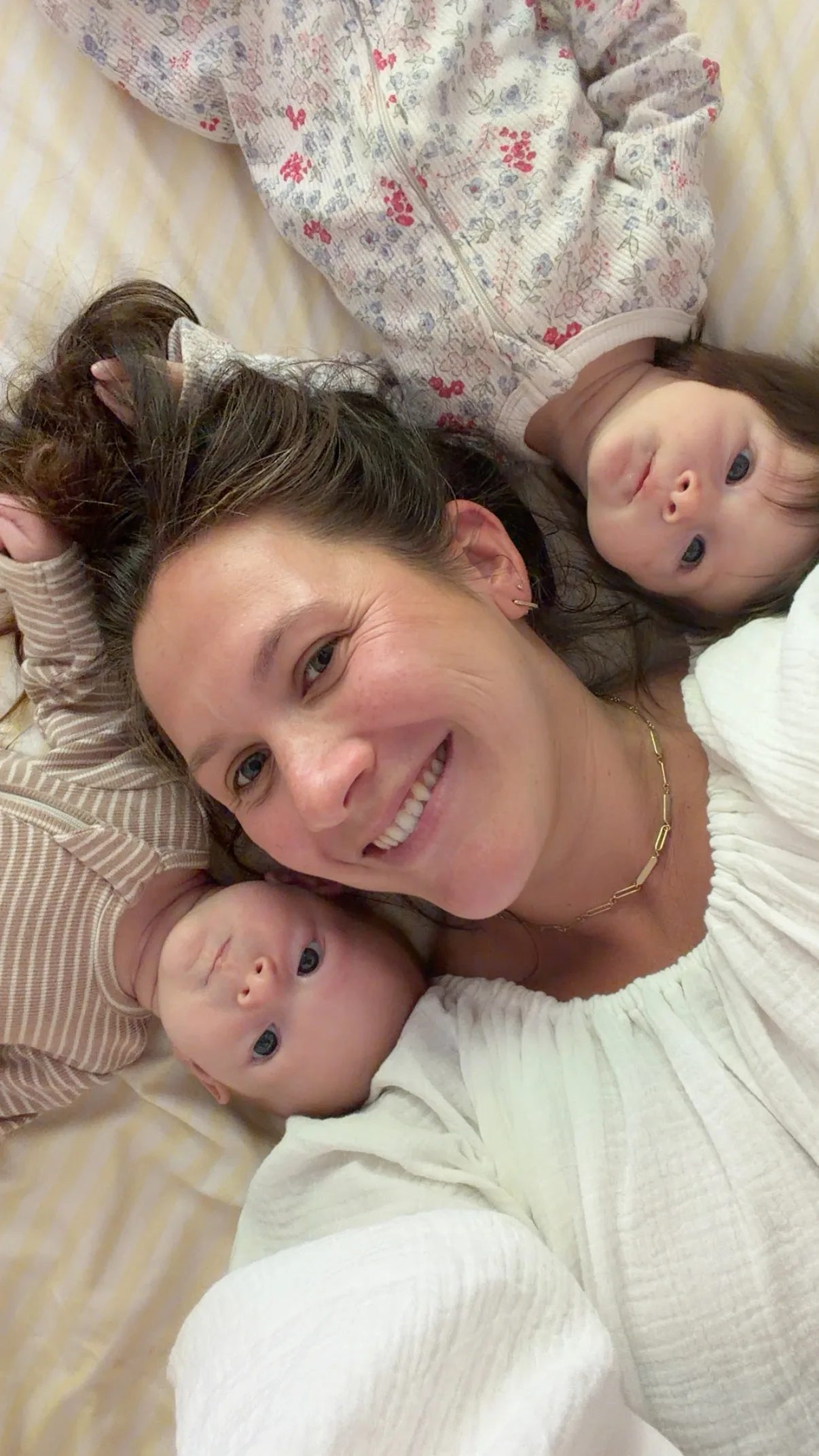 mum smiling in bed with twin babies