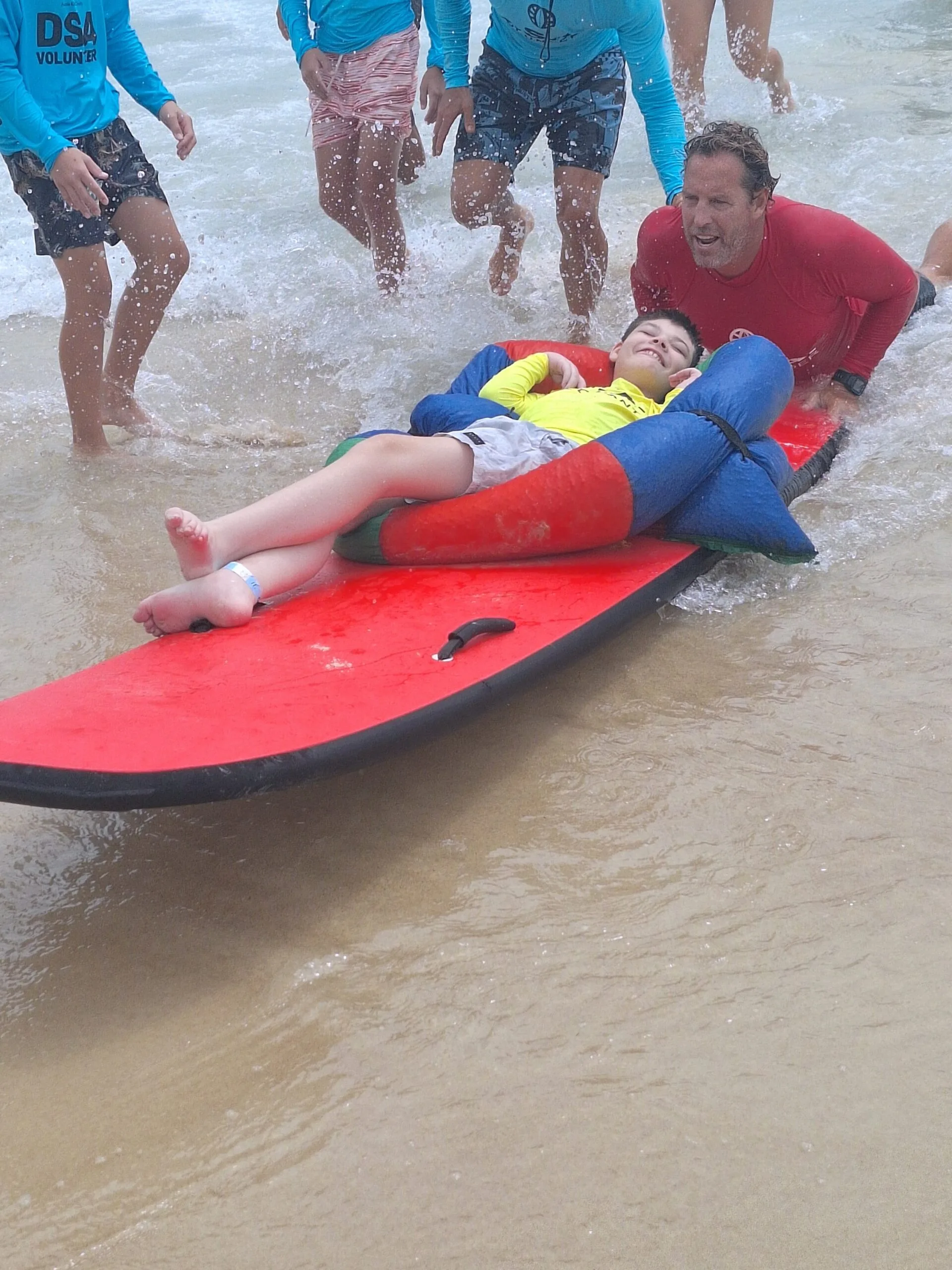 boy laying down on surfboard