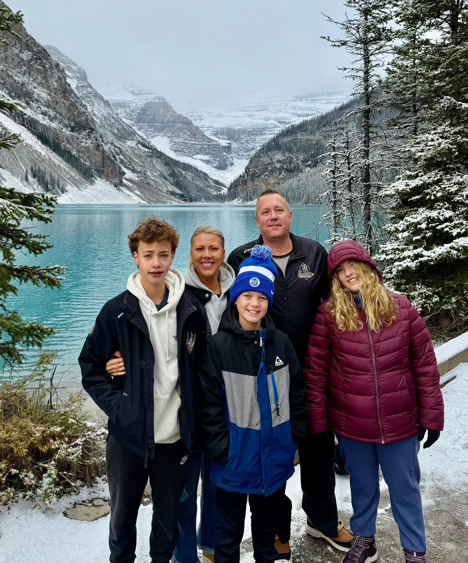 Image of Kari's family on vacation. They are all wearing thick jackets and long pants to keep them warm in the snow.